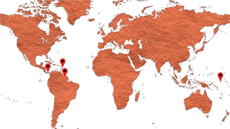 stilisierte Weltkarte in Sandfarbe mit Pins auf den Ländern Guayana, Panama, Montserrat, Nauru