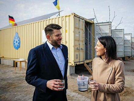 Bundesaußenministerin Baerbock und Boreal Light Mitgründer Ali Al-Hakim vor der solarbetriebenen Wasserentsalzungsanlage in der Ukraine.