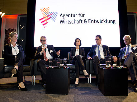 Gerd Müller mit vier weiteren Personen sitzend auf dem Podium vor AWE Hintergrund