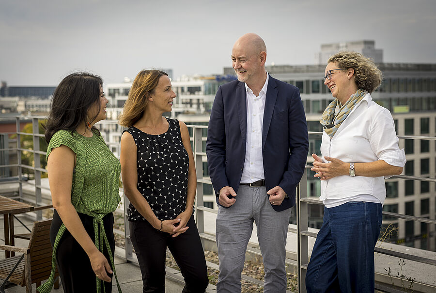 Karla Beteta, Danica Hüsken, Volker Adams und Martina von Münchhausen im Gespräch auf einer Dachterrasse