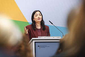 Eine Frau steht hinter einem Rednerpult.