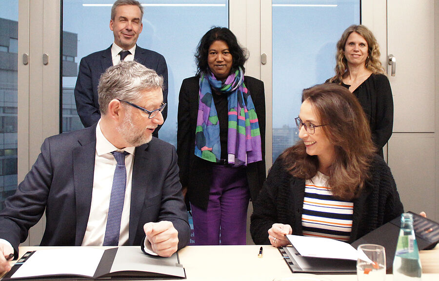 Auf dem Bild sieht man: Thorsten Schäfer-Gümbel (GIZ) und Yasim Fahimi (DGB) unterzeichnen die Kooperationsvereinbarung zwischen GIZ und DGB. Im Hintergrund v.l.n.r. Bernhard Von der Haar, (GIZ), Ina Hommers (GIZ), Annika Wünsche (DGB)