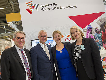 Gruppenfoto mit Corinna Franke-Wöller mit AWE Messestand im Hintergrund