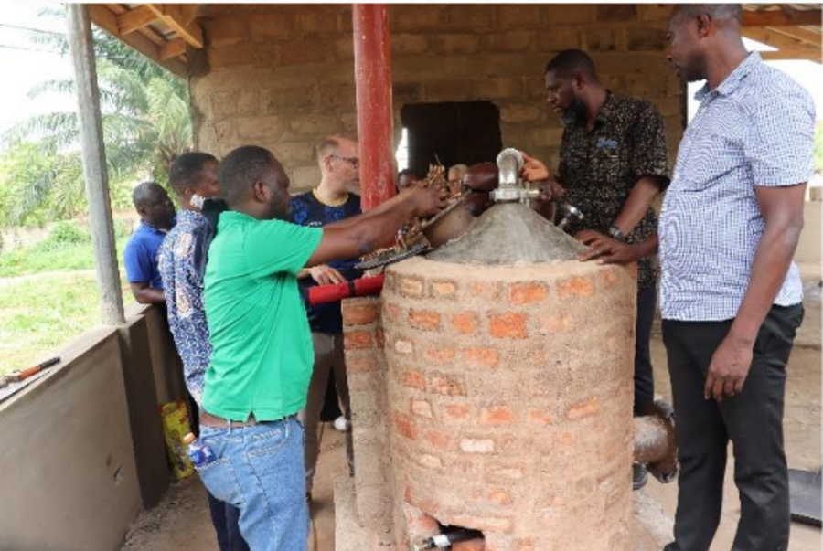 Mehrere Männer an einem Pyrolyse-Ofen in Ghana