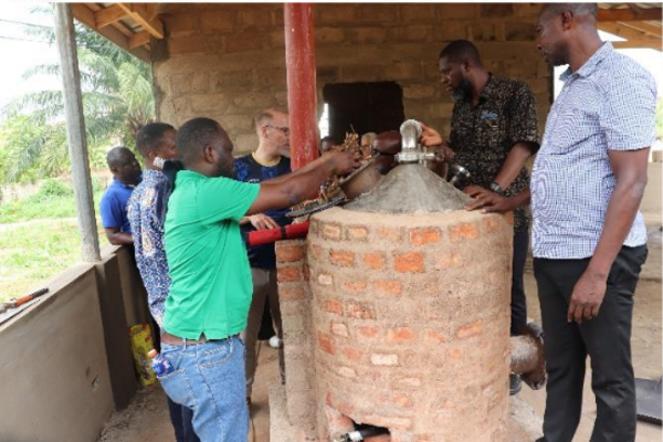 Mehrere Männer an einem Pyrolyse-Ofen in Ghana