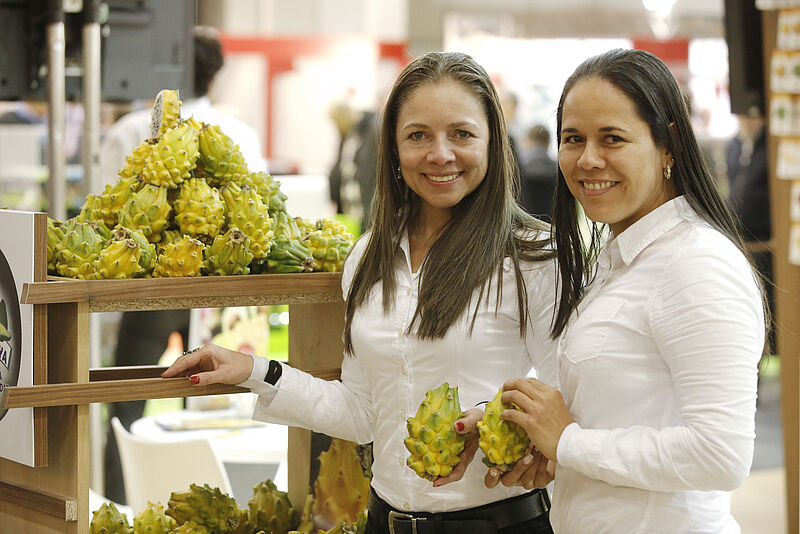 Zwei kolumbianische Frauen präsentieren Früchte auf der Messe Fruit Logistica