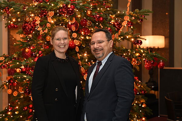 Dr. Corinna Franke-Wöller und Orlando Baquero vor einem Weihnachtsbaum