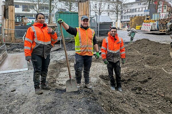 3 athiopische und deutsche Fachkr&auml;fte mit Warnwesten arbeiten auf einer Baustelle