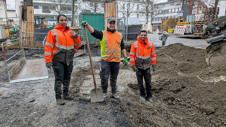 3 athiopische und deutsche Fachkr&auml;fte mit Warnwesten arbeiten auf einer Baustelle