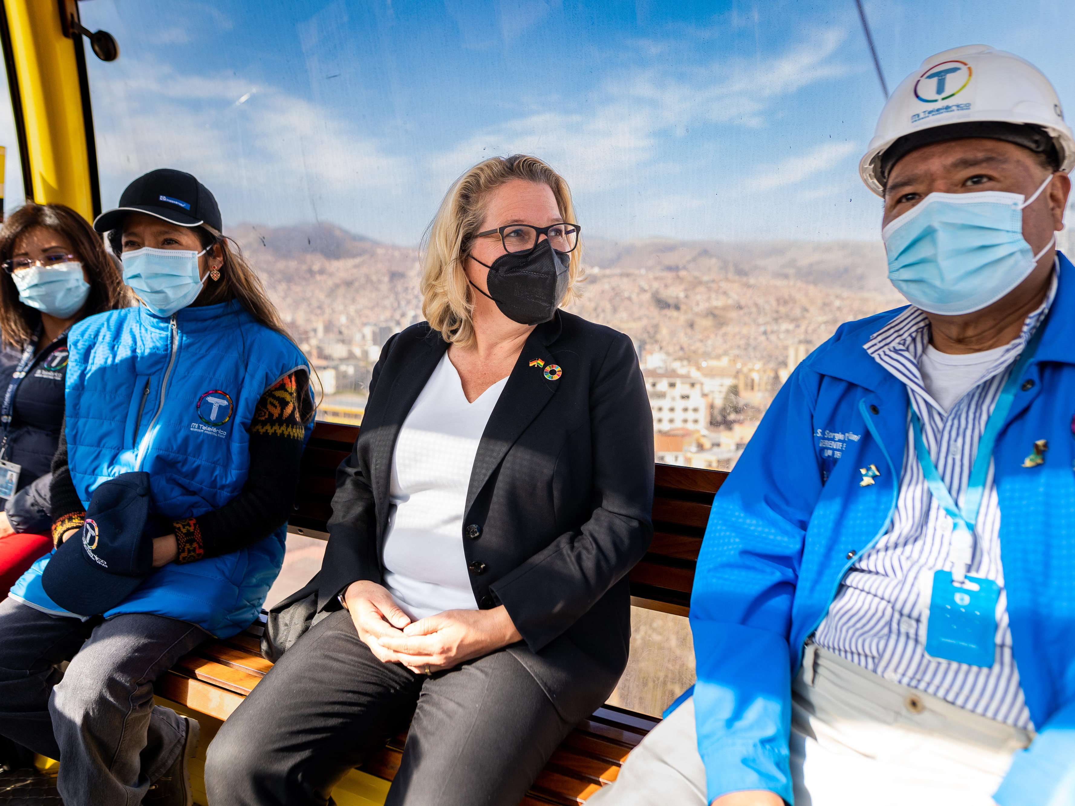 Auf dem Bild sind vier Personen abgebildet, die sich in großer Höhe in einer Art Gondel befinden und Masken tragen – darunter Entwicklungsministerin Svenja Schulze.